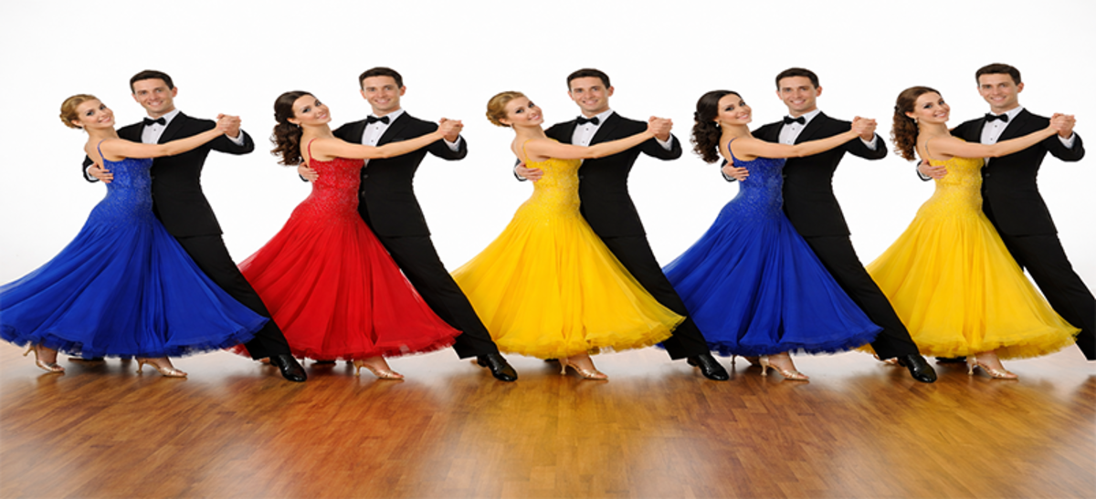 A synchronized ballroom and Latin group routine performed by smiling dancers